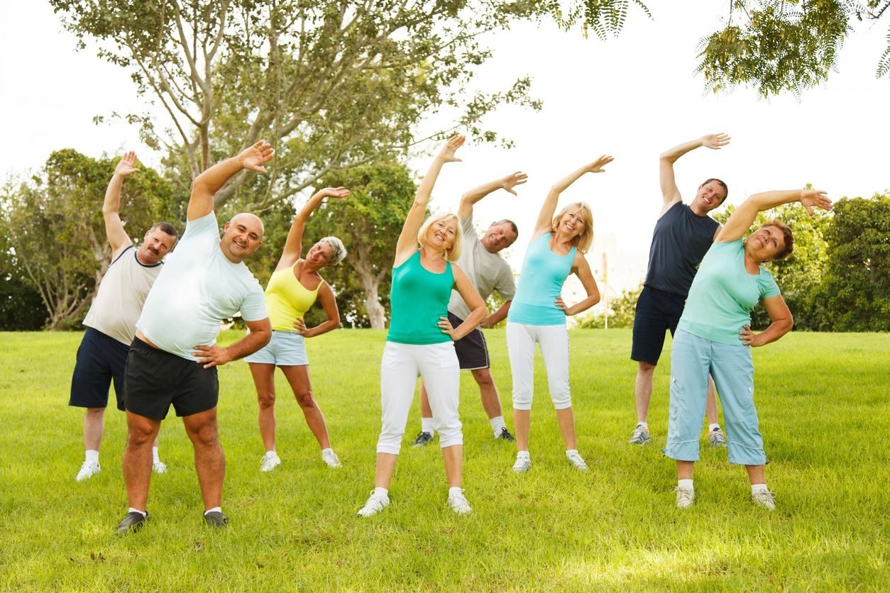 A group of people doing different exercises in the park.