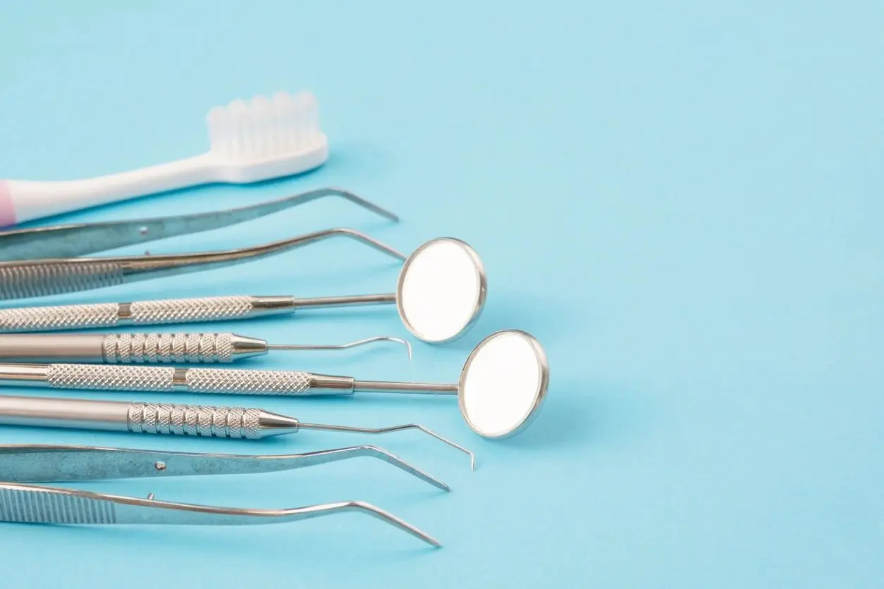 A group of dental instruments on top of a blue table.