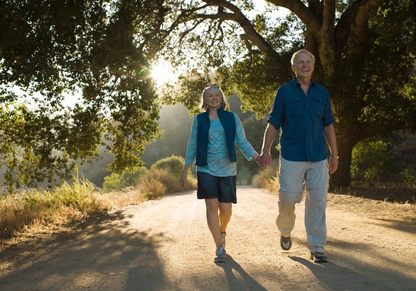 A man and woman walking down the road holding hands.